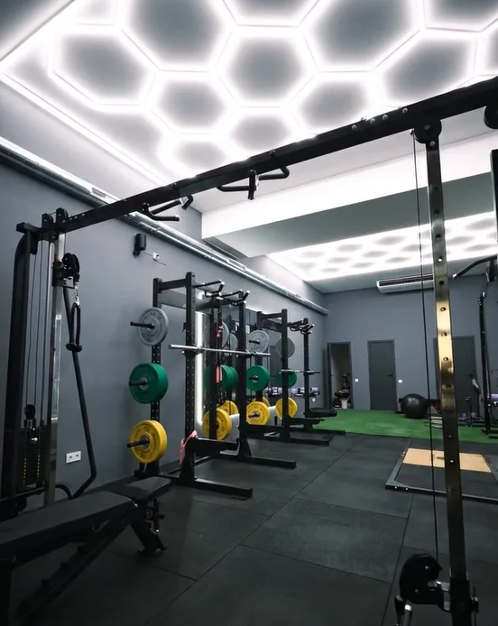 Sala de Barcelona Barbell Club con racks, discos y zona de césped funcional